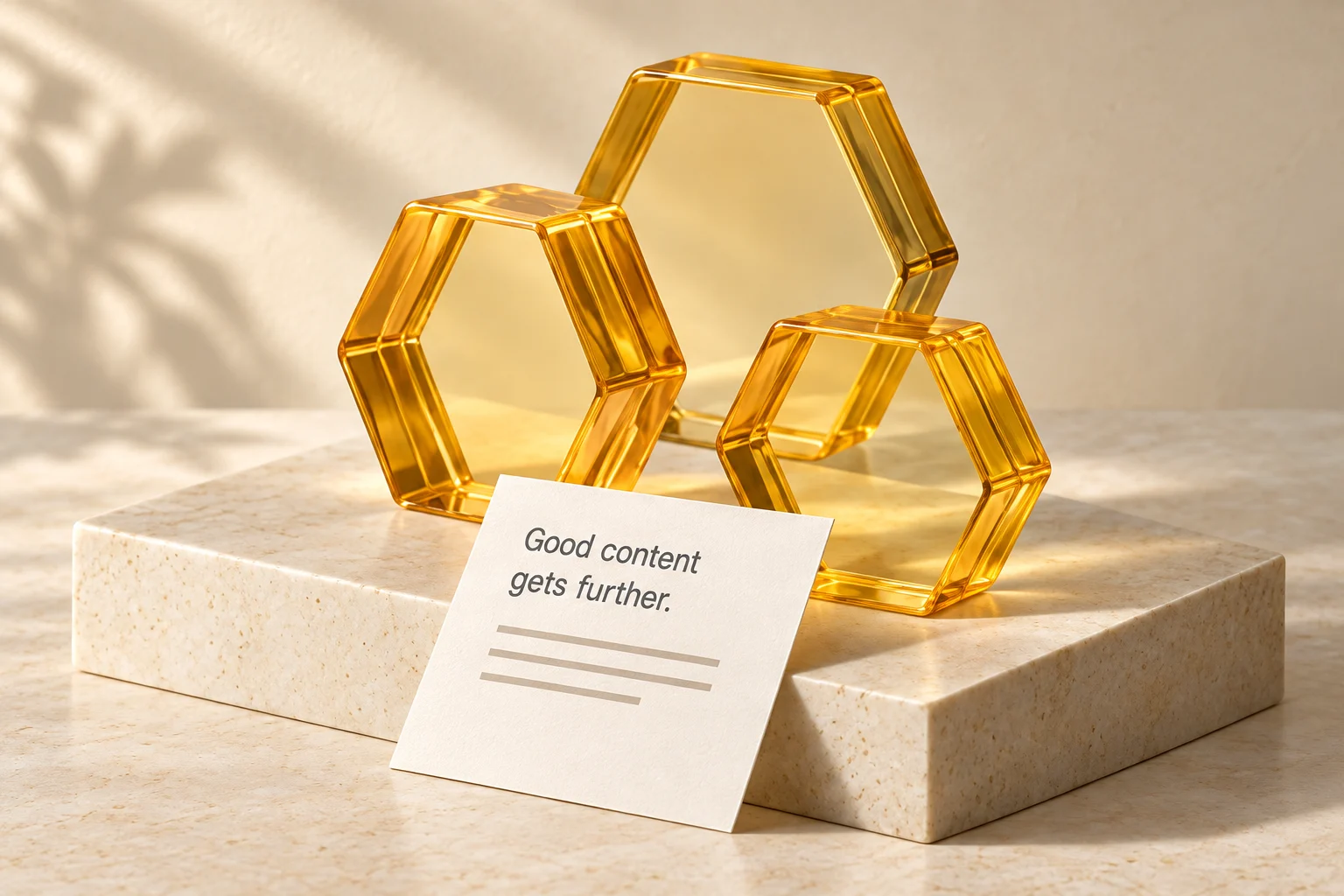 Three amber glass hexagonal frames on ivory stone, with a card reading Good content gets further.